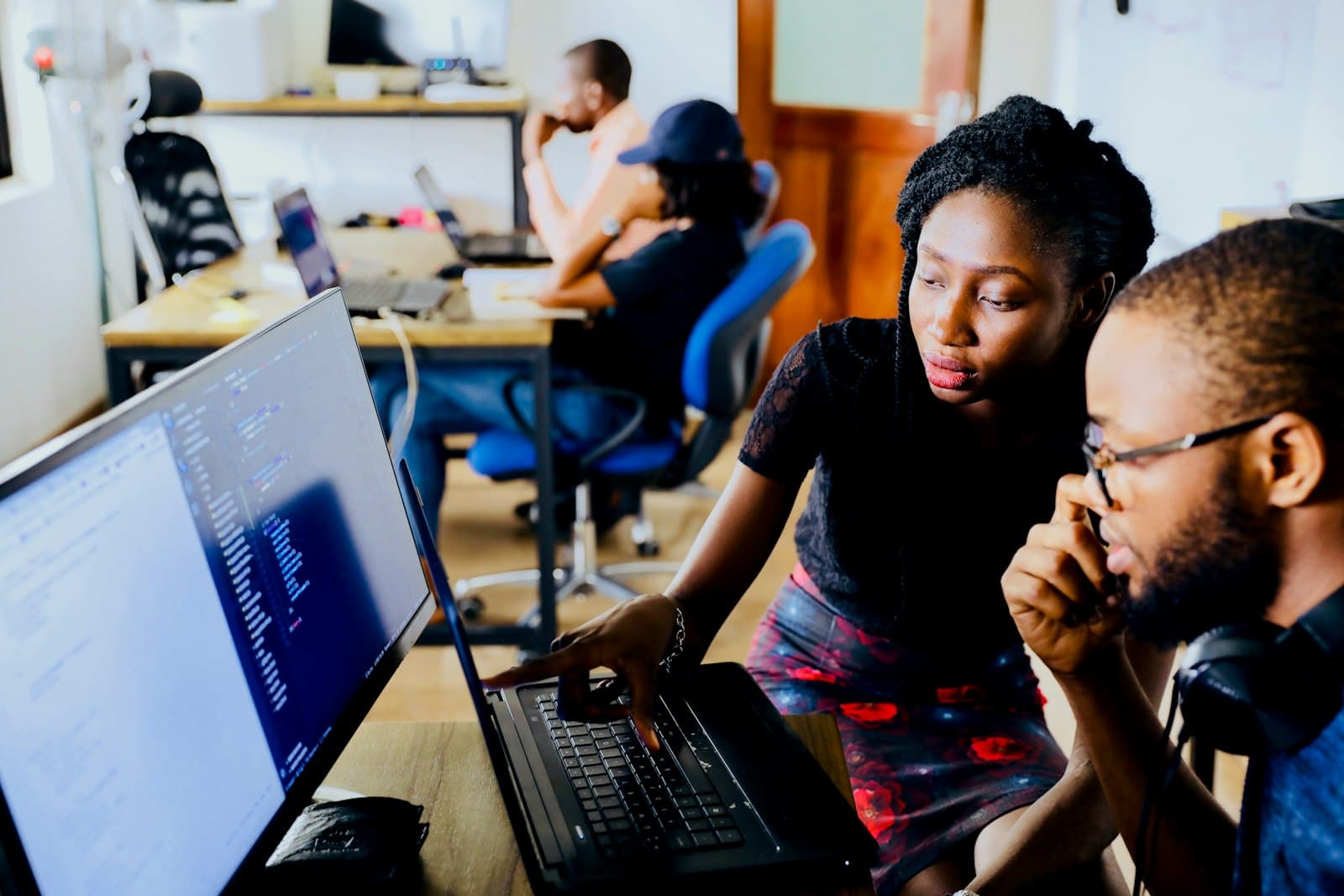 Deux ingénieurs devant du code affiché sur un écran