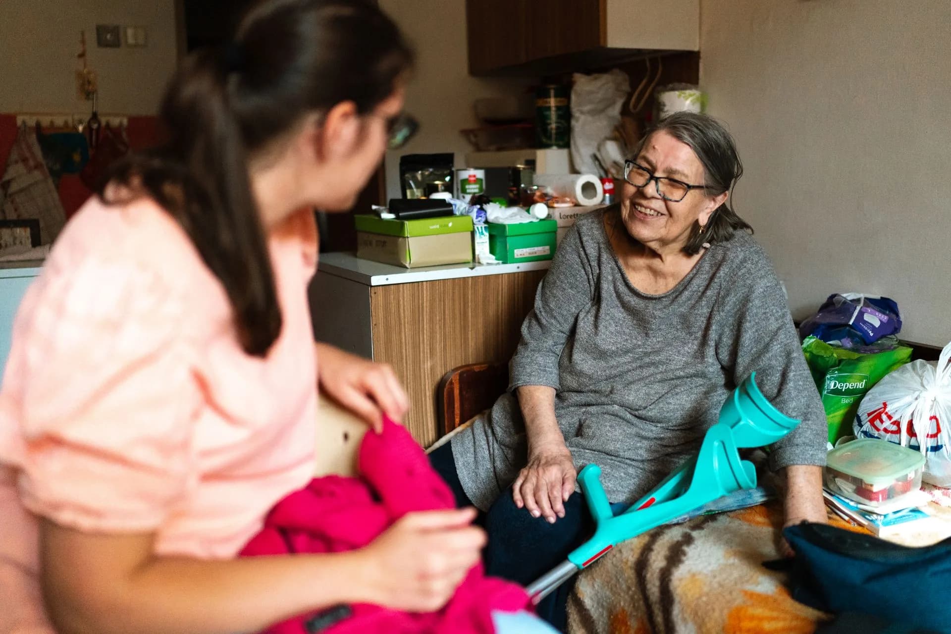 Intervenante à domicile accompagnant une personne âgée qui se déplace avec une béquille