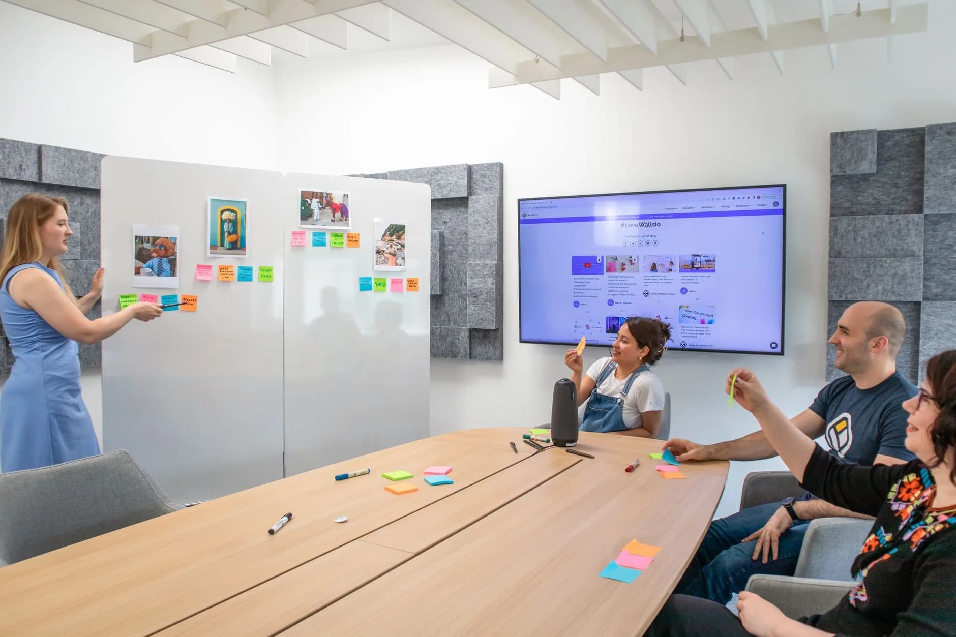 Atelier collaboratif en salle de réunion, avec des post-it collés au mur et un écran de partage