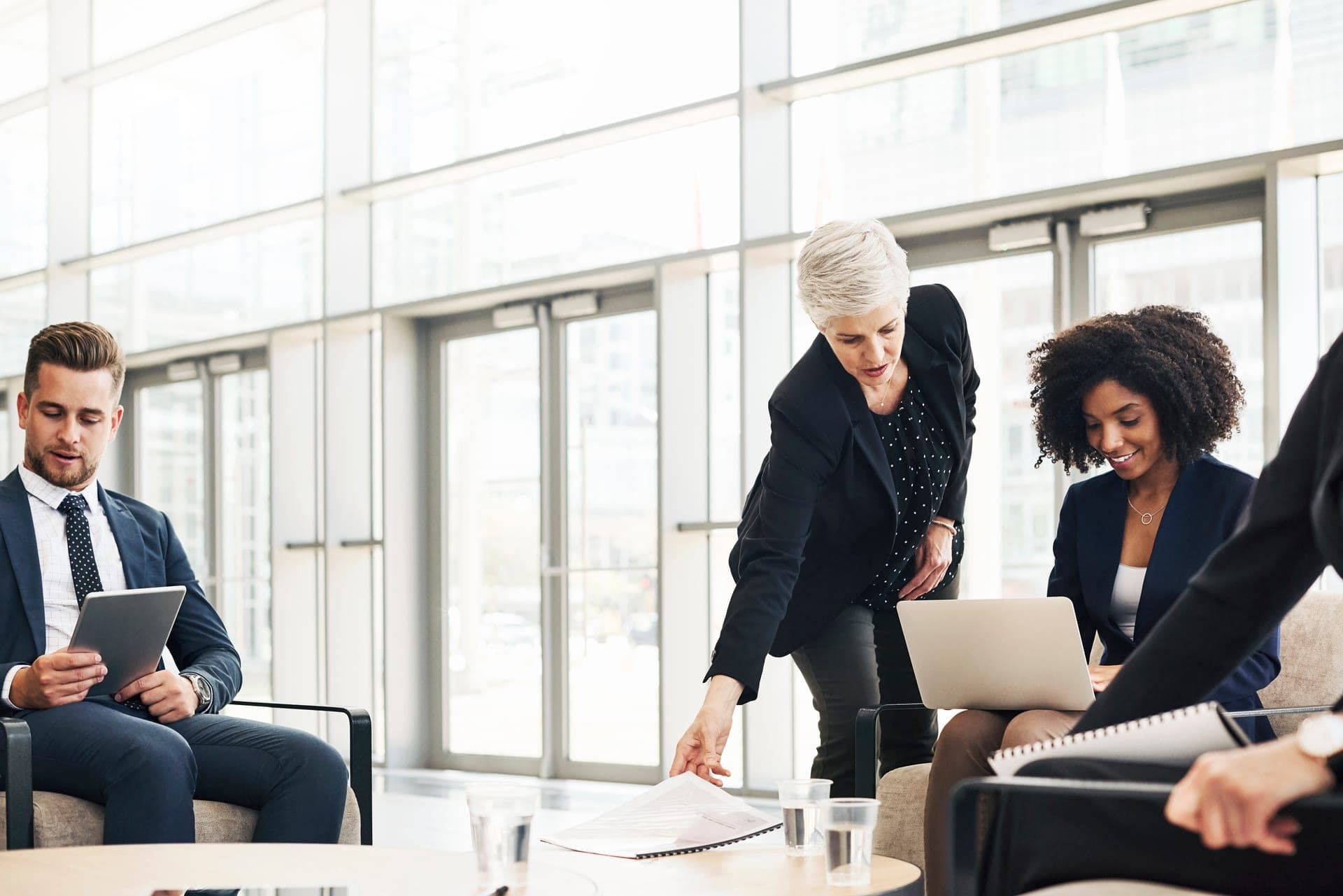 Équipe d'une PME réunie autour d'ordinateurs portables dans un bureau lumineux