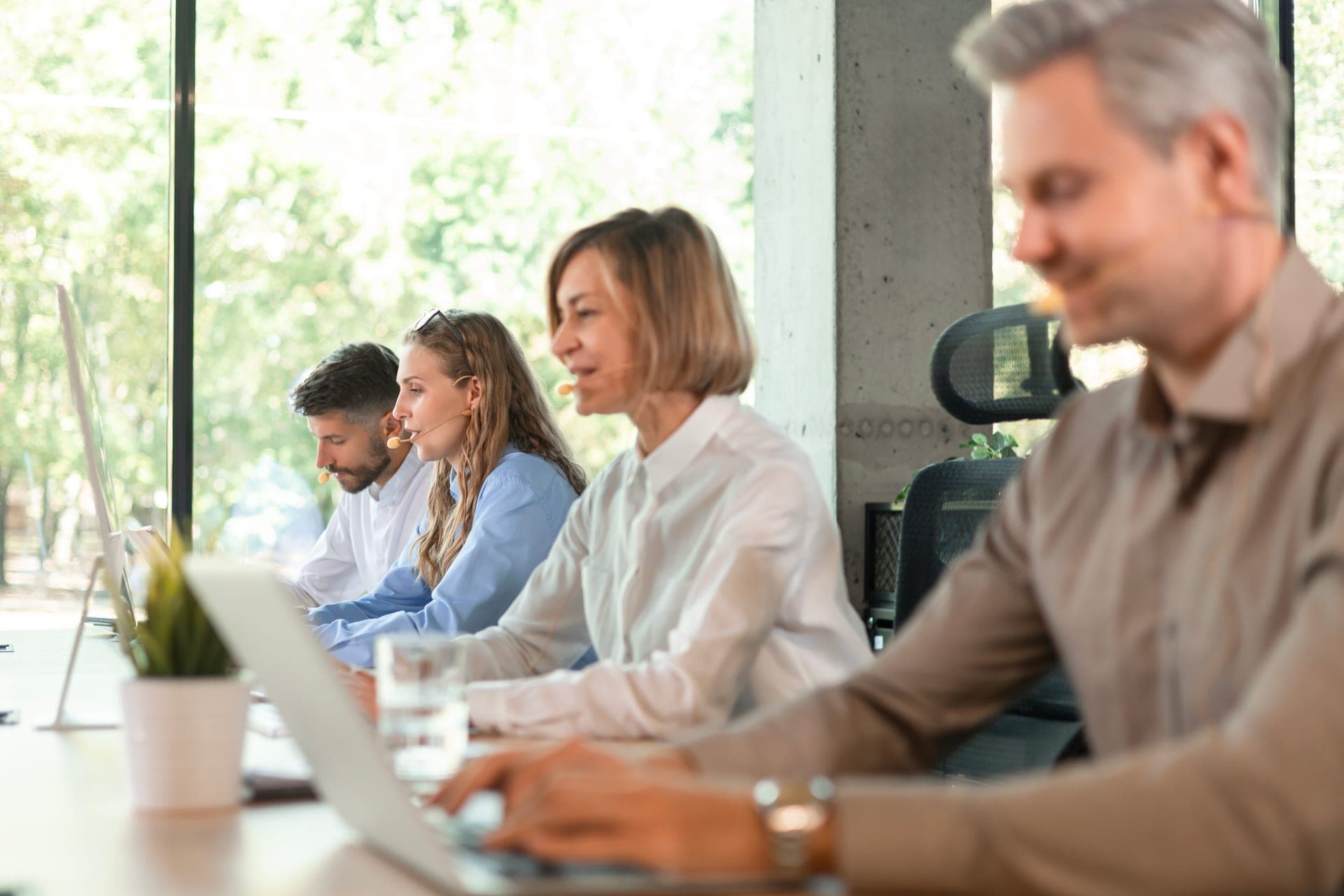 Équipe diverse d'une entreprise tech au travail autour d'un ordinateur portable