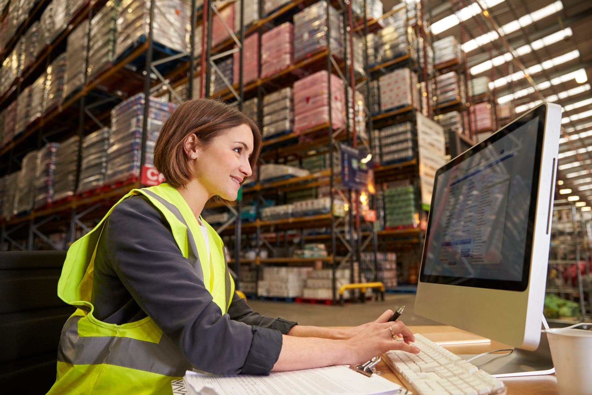 Entrepôt de distribution avec bacs et colis stockés sur rayonnages