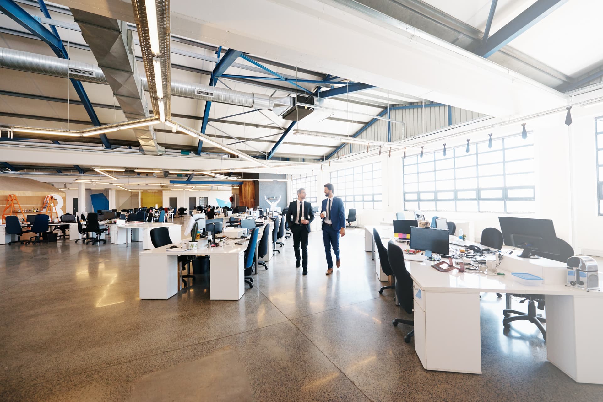 Vaste plateau de bureaux d'un siège social avec des équipes au travail