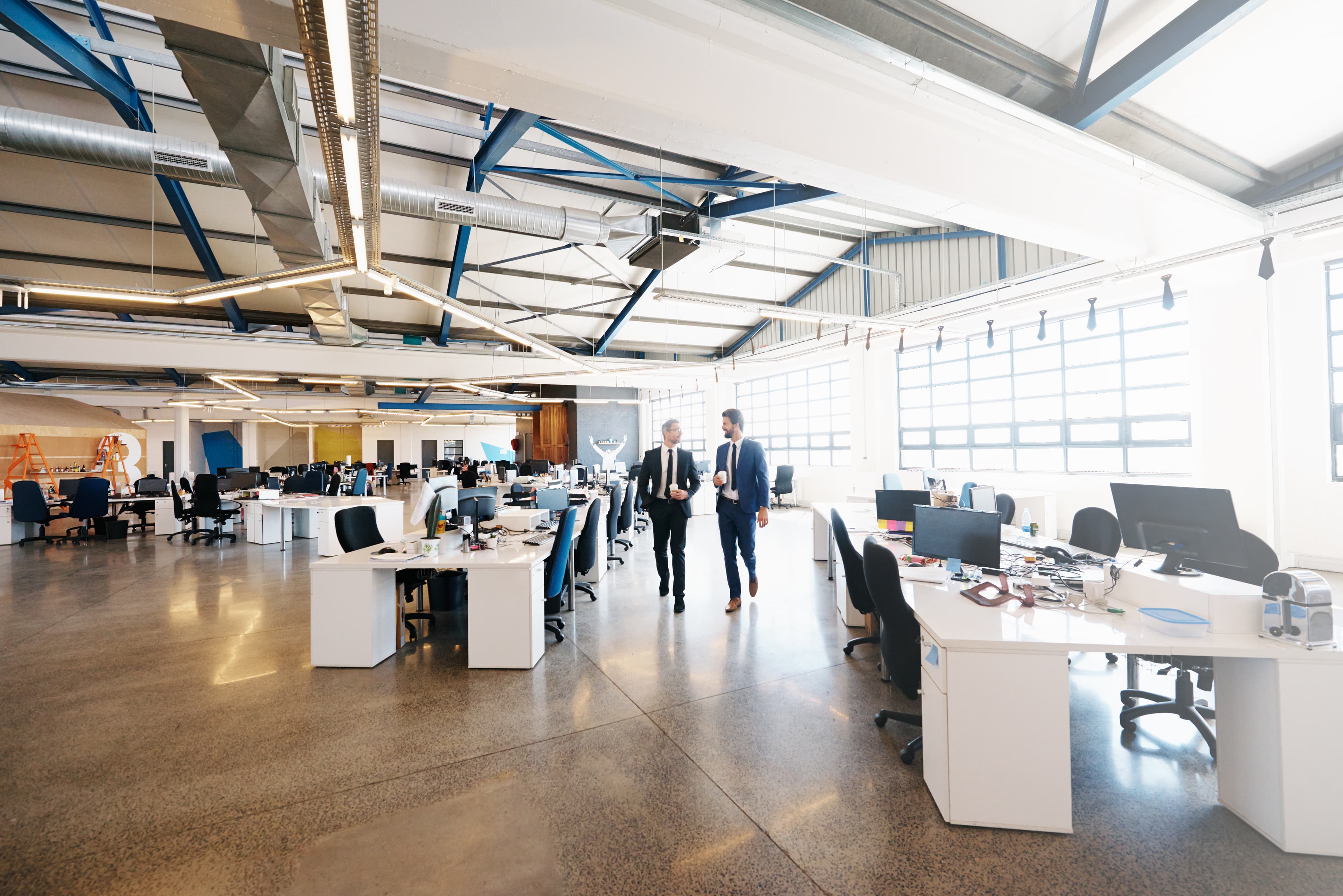 Vaste plateau de bureaux d'un siège social avec des équipes au travail