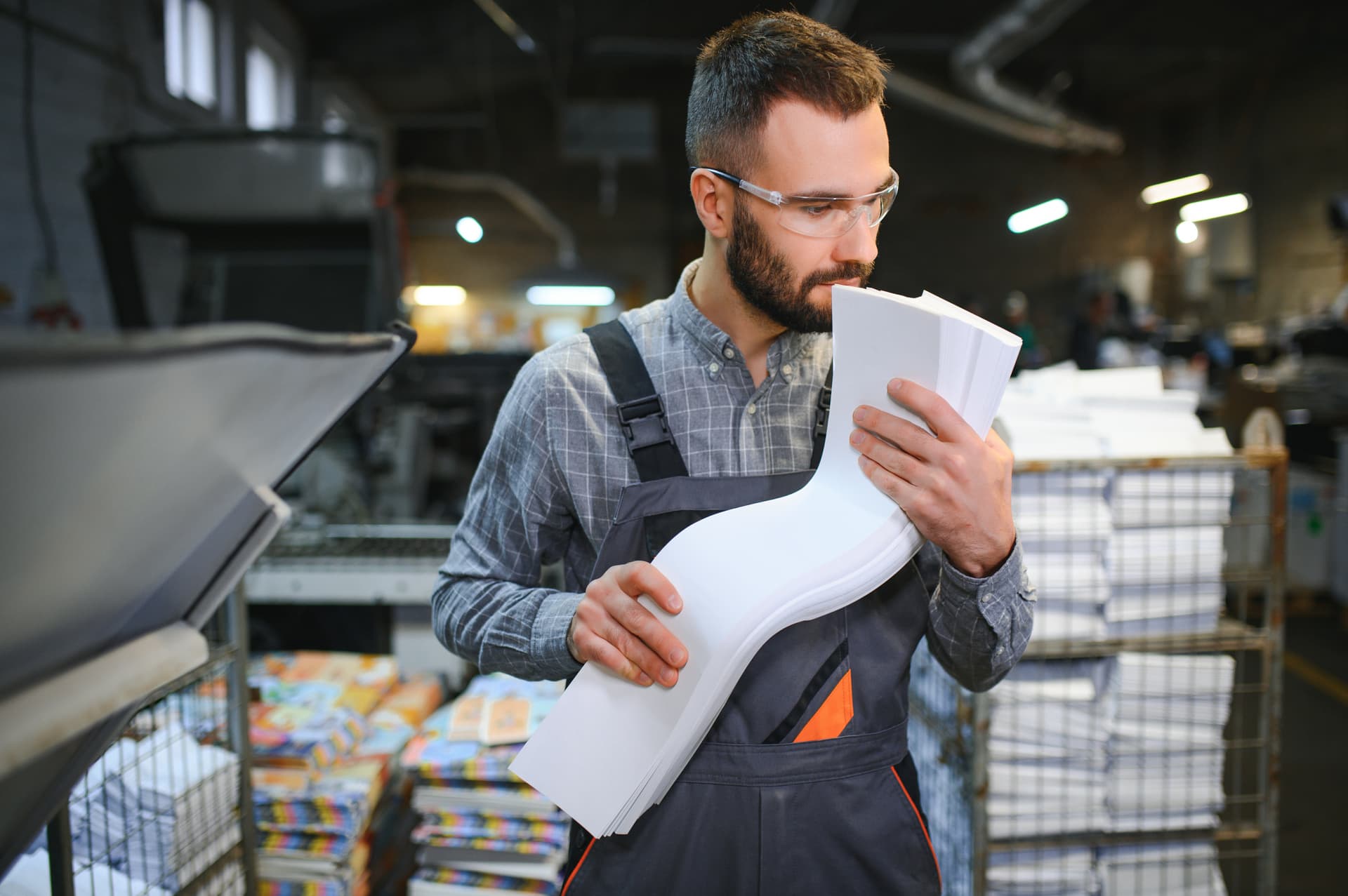 Opérateur consultant des documents techniques au pied d'une ligne de production