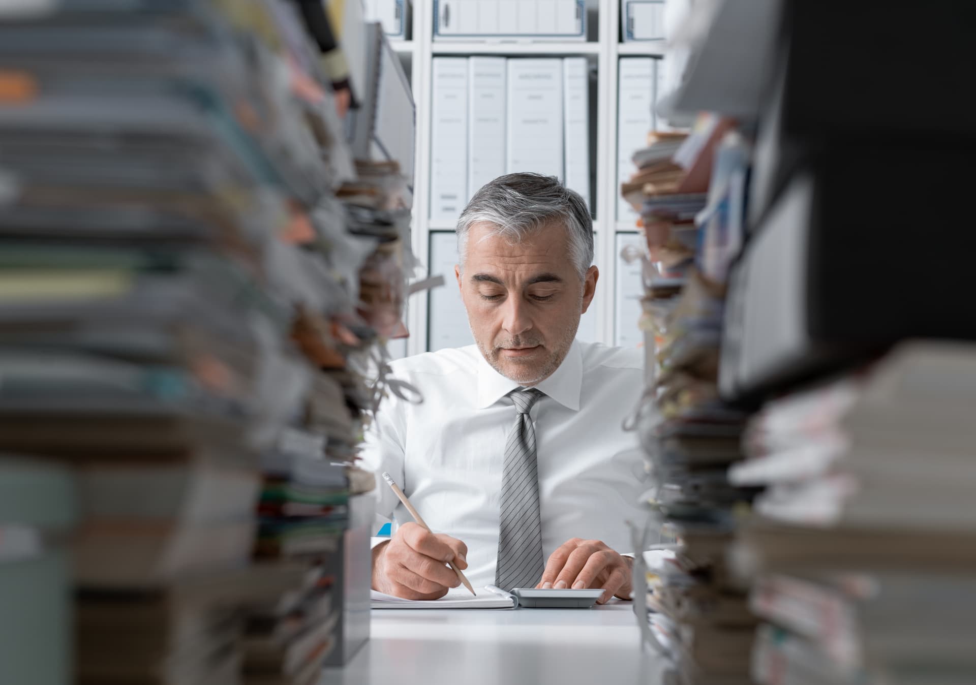 Juriste travaillant entre des piles de dossiers dans un cabinet
