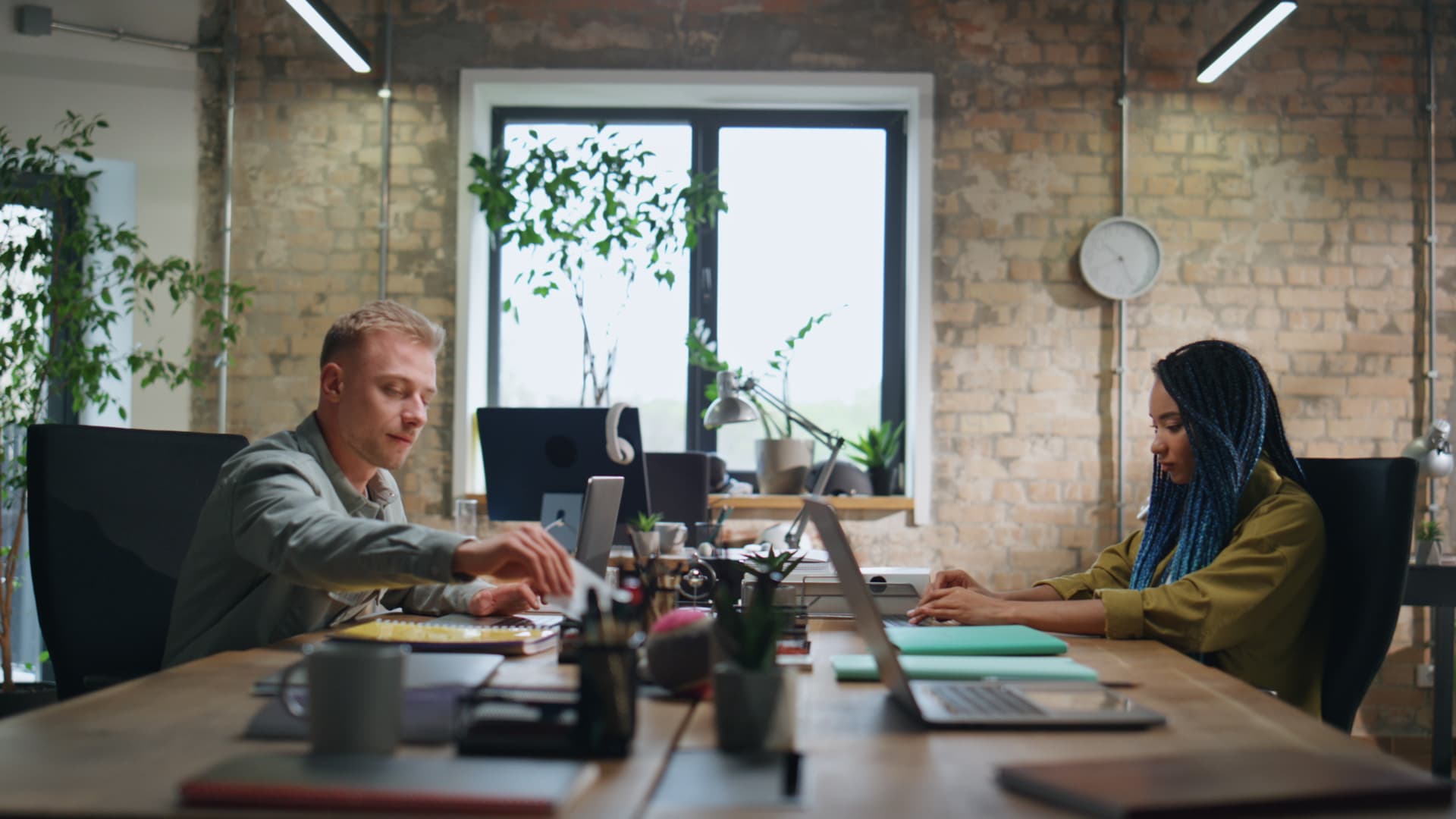 Équipe d'une jeune entreprise au travail autour d'une grande table