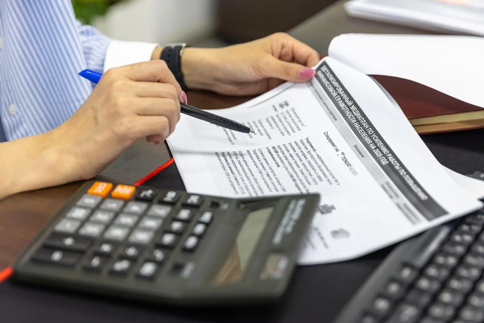 Chiffrage d'un business case : rapport imprimé annoté au stylo, calculatrice posée à côté
