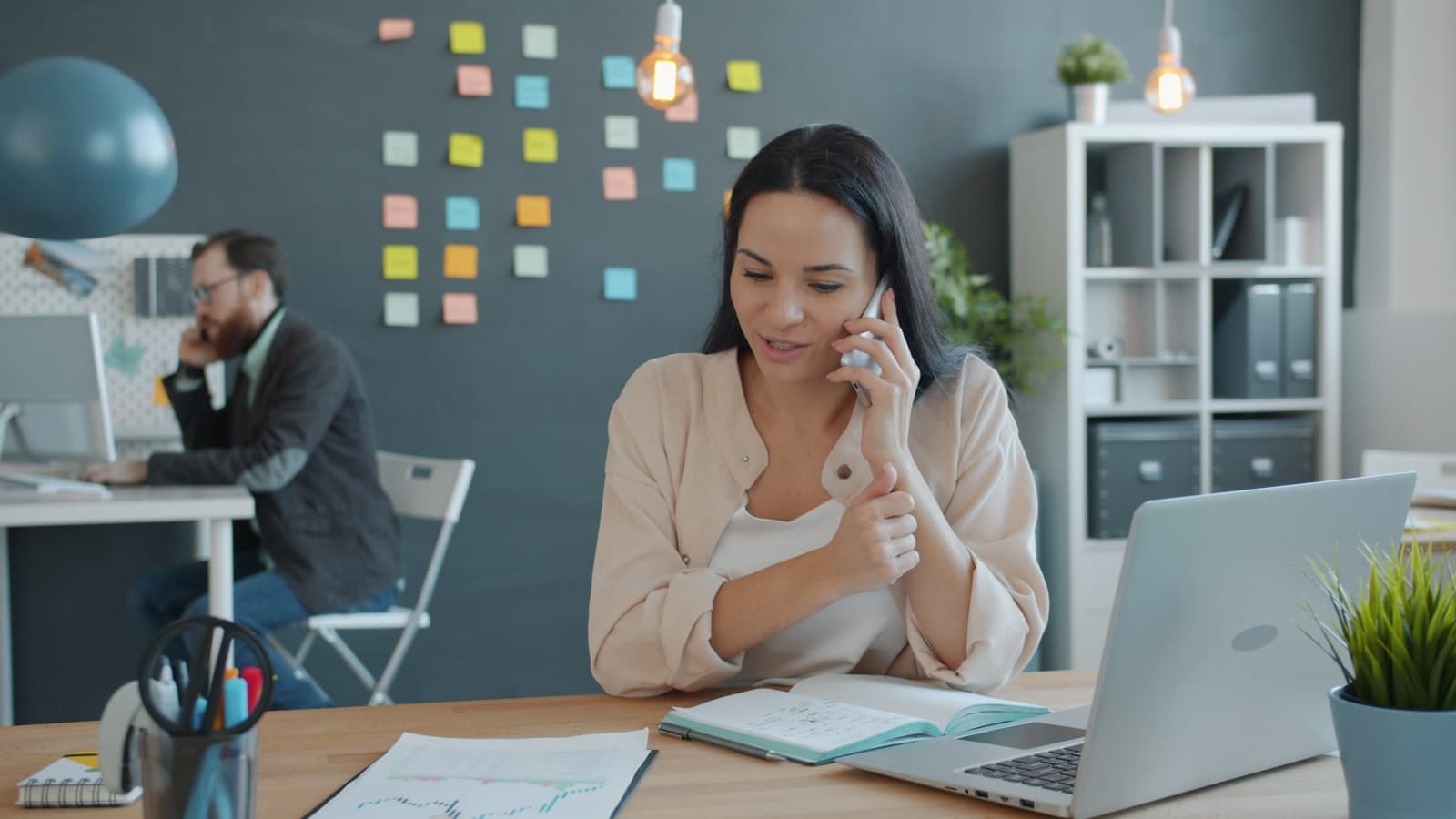 Collaboratrice prenant un rendez-vous par téléphone au bureau