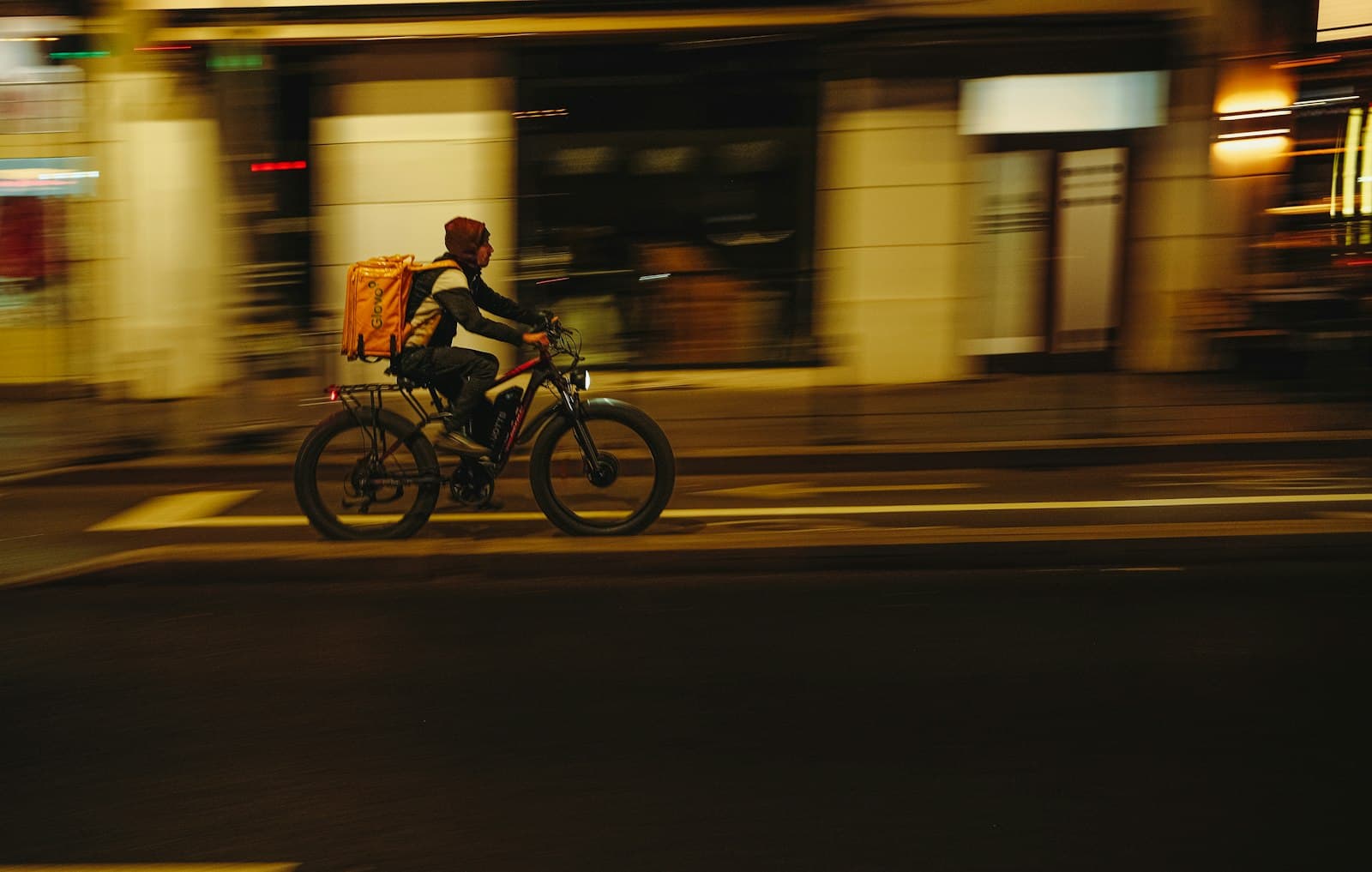 Livreur du dernier kilomètre traversant la ville de nuit à vélo