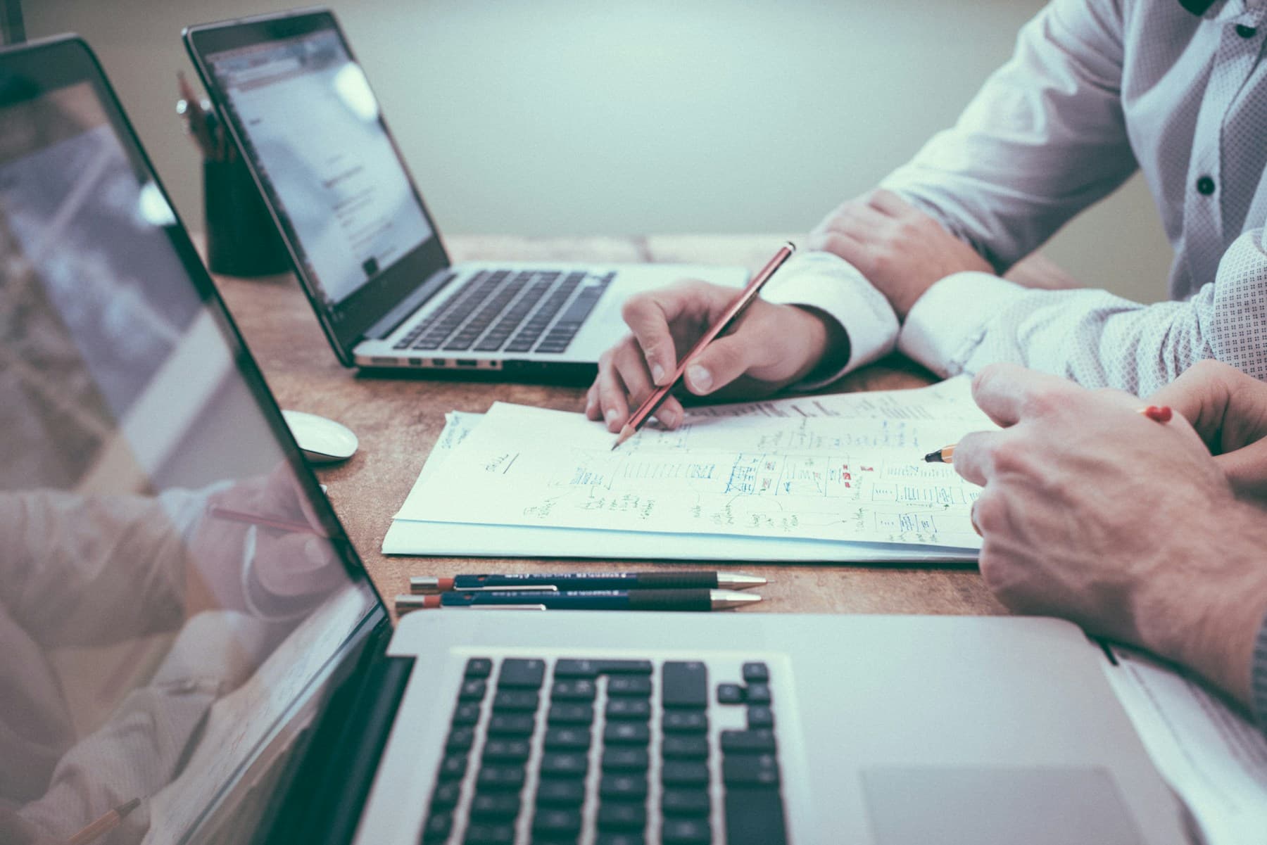 Dirigeant et conseiller travaillant sur un dossier entre deux laptops