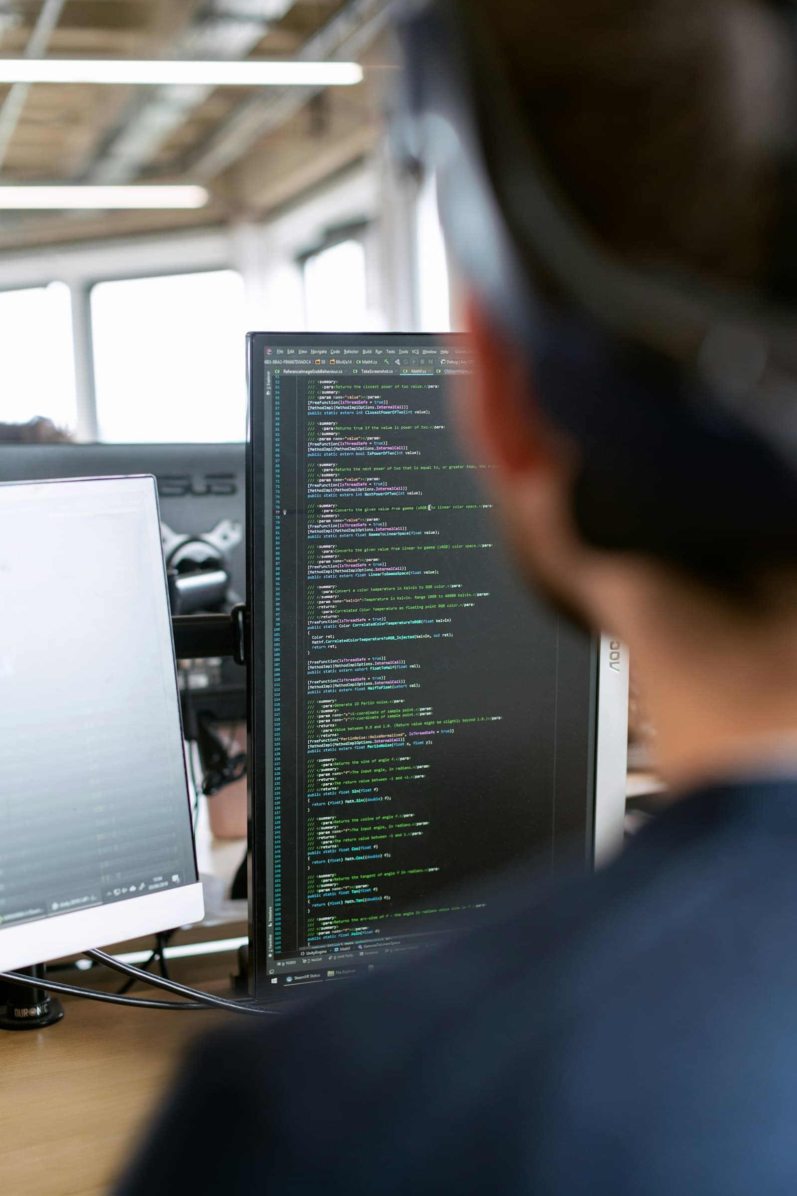 Développeur travaillant sur du code devant plusieurs écrans